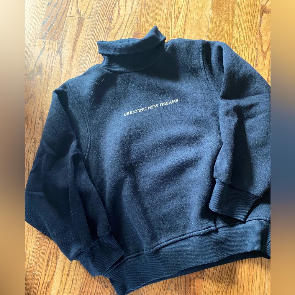 Black sweater with turtle neck. Print : Creating new dreams